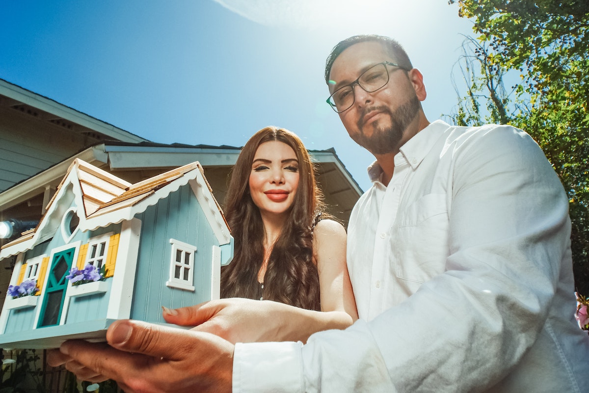 Man-and-woman-holding-a-miniature-house